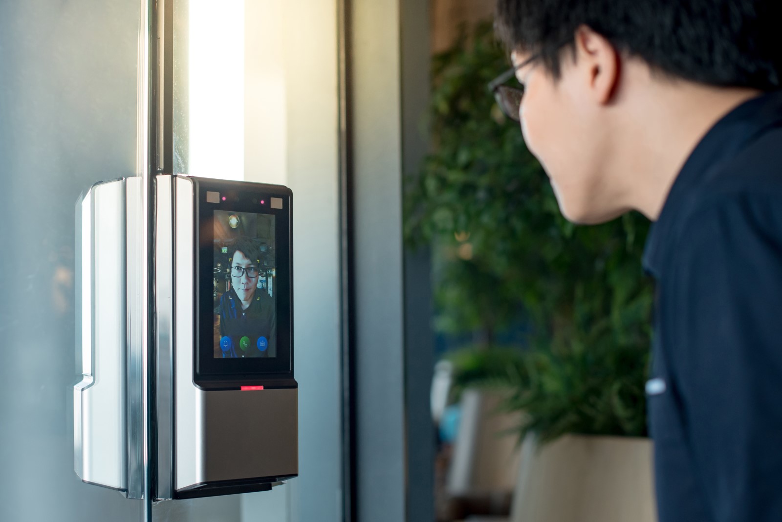 An employee gains access to an office by using a facial recognition biometric security reader.